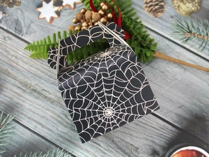 Top view of a black Halloween cake box with spider web patterns on a wooden surface