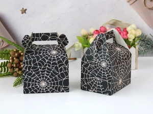 Detail of Halloween black paper cake boxes with white spider web pattern and handles