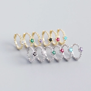 Detailed grid of s925 silver dagger earrings with colorful zircons in gold and silver finish