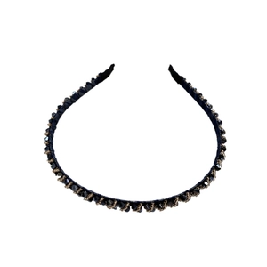 Minimalist gold band headband with sparkling black crystal beads on a white background