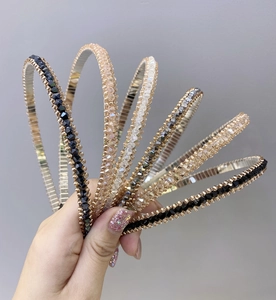 Detail of slim crystal headbands in assorted colors like black, champagne, and white