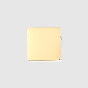 Macro shot of polished gold square stainless steel pendant with reflective metallic finish