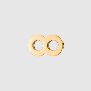 Macro detail of a golden infinity symbol charm with dual holes for jewelry making