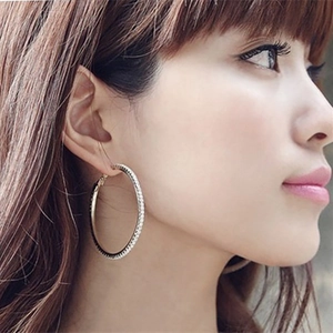 Chic oversized gold hoop earrings with sparkling rhinestones worn by a model in profile