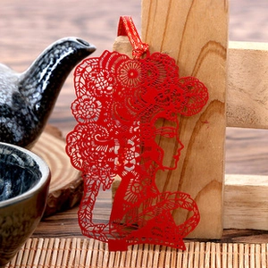Exquisite hollowed-out red metal bookmark with a classical female silhouette and ribbon
