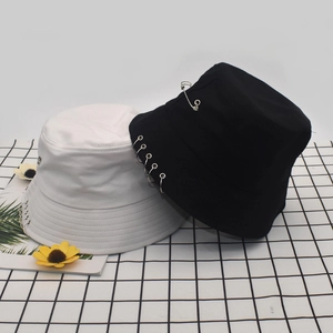 Unisex cotton bucket hats in black and white with metal rings and safety pin accents
