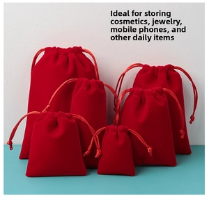 Macro view of multiple sizes of plush red velvet drawstring pouches for jewelry storage