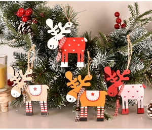 Close-up of four colorful wooden reindeer ornaments hanging on a festive Christmas tree branch