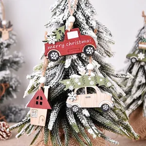 Wooden Christmas truck and reindeer ornaments hanging on a snowy Christmas tree branch