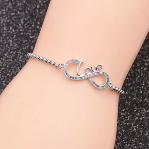 Detailed view of silver infinity Love bracelet with colorful rhinestones on a model wrist