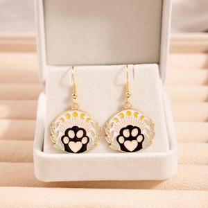 Detail showing cartoon cat paw earrings with gold finish and colorful enamel coating