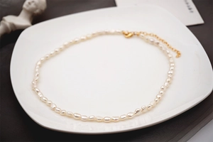 Dettaglio collana di perle d'acqua dolce barocche con chiusura a moschettone dorata