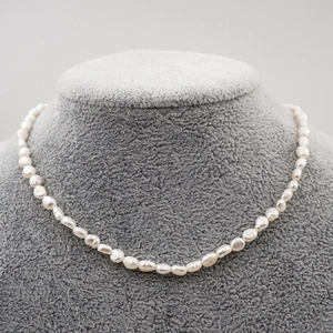 Collana girocollo di perle d'acqua dolce barocche bianche su supporto grigio