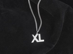Macro shot of silver XL letter pendant necklace on black velvet background