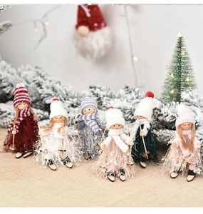 Close-up of wooden ski girl ornaments with knitted hats and faux fur on linen background