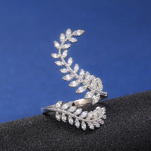 Elegant silver leaf ring with cubic zirconia stones on dark textured background