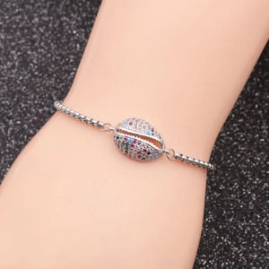 Detail of adjustable silver box chain bracelet featuring a shell charm with colorful zircons
