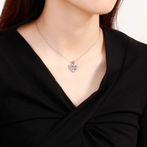 Collier cœur argenté avec gravure love porté par un mannequin sur fond blanc