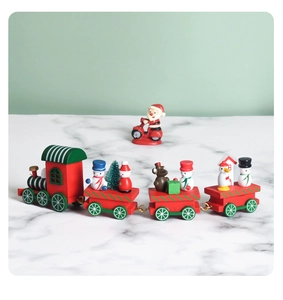 Close-up of wooden Christmas train toy with snowman and tree figures on white marble