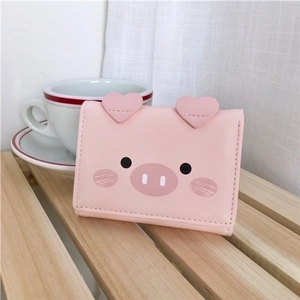 Pink cartoon pig trifold wallet for women on a light wood surface with a soft background