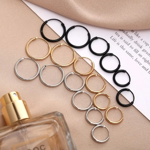Classic hoop earrings set in black gold and silver tones on elegant silk background