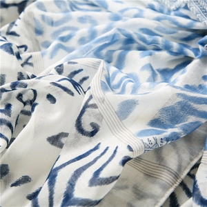 Detail showing soft cotton-linen fabric texture with blue tie-dye wave print patterns