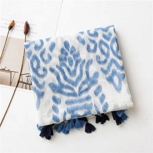 Detail of cotton linen scarf featuring blue ethnic ikat print and dual-tone blue tassels