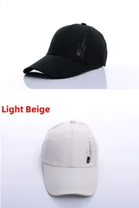 Detail view of cotton baseball caps in black and light beige with side logo printing