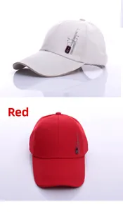 Close-up of red and beige cotton baseball caps showing side badges and stitched details