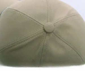 Detail shot of khaki cotton baseball cap crown with seven-panel stitching and top button