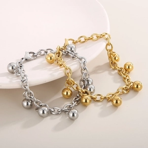 Detailed macro view of gold and silver beaded chain bracelets in polished stainless steel