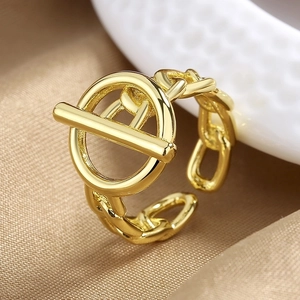 Macro shot of gold OT-toggle link ring with polished finish on silk background