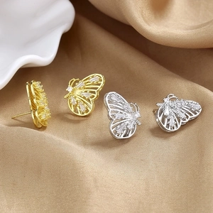 Elegant gold and silver butterfly earrings with sparkling cubic zirconia on silk fabric