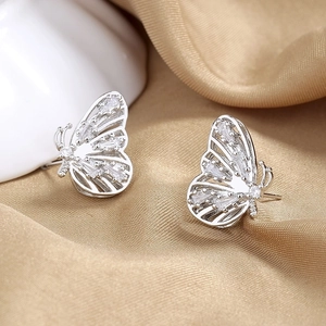 Elegant silver butterfly stud earrings with sparkling white zircons on silk fabric