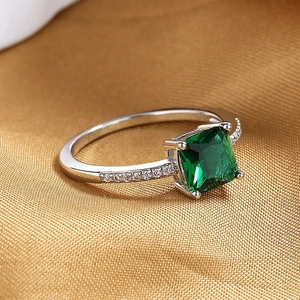 Vintage emerald square zircon ring with silver band and small diamonds on gold fabric