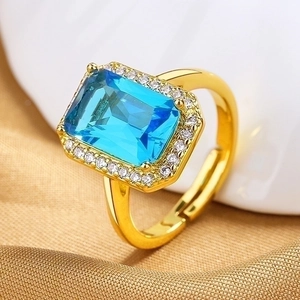 Vintage gold open ring featuring a rectangular aquamarine gemstone with a halo of zircons