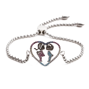 Close-up of heart charm with boy and girl silhouettes on silver chain bracelet