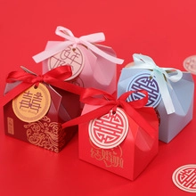 Macro shot of wedding candy boxes in four colors with satin ribbons and embossed paper