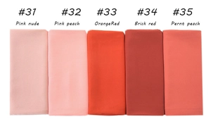 Detail view of pearl chiffon shawls in assorted pink, orange and brick red shades