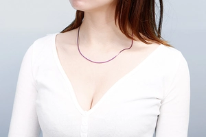 Close-up of a slim purple stainless steel snake chain necklace on a model