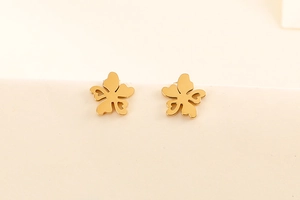 Détail de boucles d'oreilles fleurs dorées avec pétales minimalistes en forme de cœur