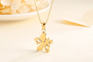 Gros plan du pendentif fleur dorée avec cœurs ajourés et strass brillants étincelants