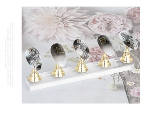 Nail art practice set with gold metal holders on a clear acrylic base with floral background