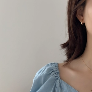 Detail view of minimalist gold plated S925 sterling silver geometric hoop earrings on model