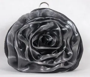 Close-up of a silver rose-shaped evening bag with layered satin fabric and metal ring