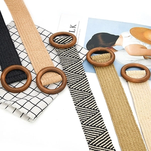 Macro shot of assorted elastic woven belts with round wooden buckles for summer dresses