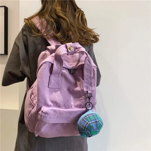 Purple canvas backpack for college women with green plaid charm hanging on the side