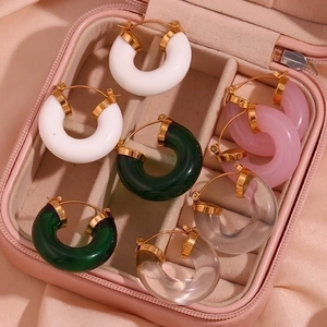 Detail of colorful acrylic hoop earrings in a pink jewelry box with silk lining
