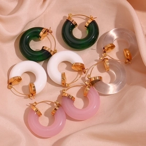 Detailed view of colorful acrylic C-shape hoop earrings on premium champagne silk fabric