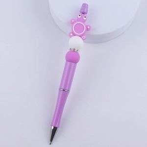 Detail of purple glitter pen featuring a cute cartoon turtle silicone bead topper